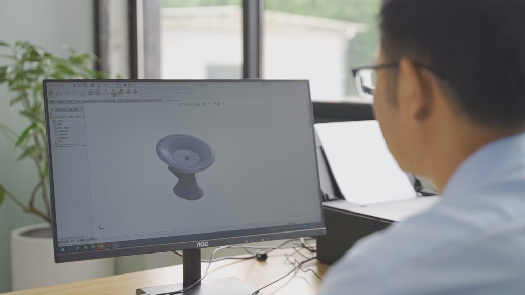 Employees operate and design products in front of computers